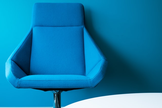 blue office chair against a blue wall background