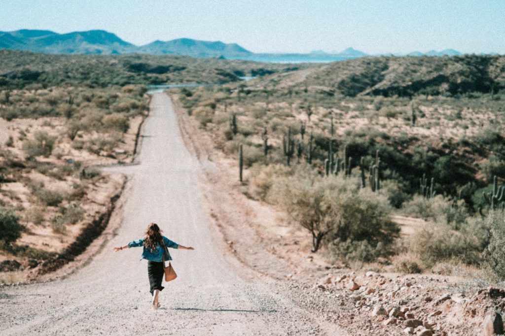 tucson, arizona, woman walking in the middle of a dirt road in the dessert