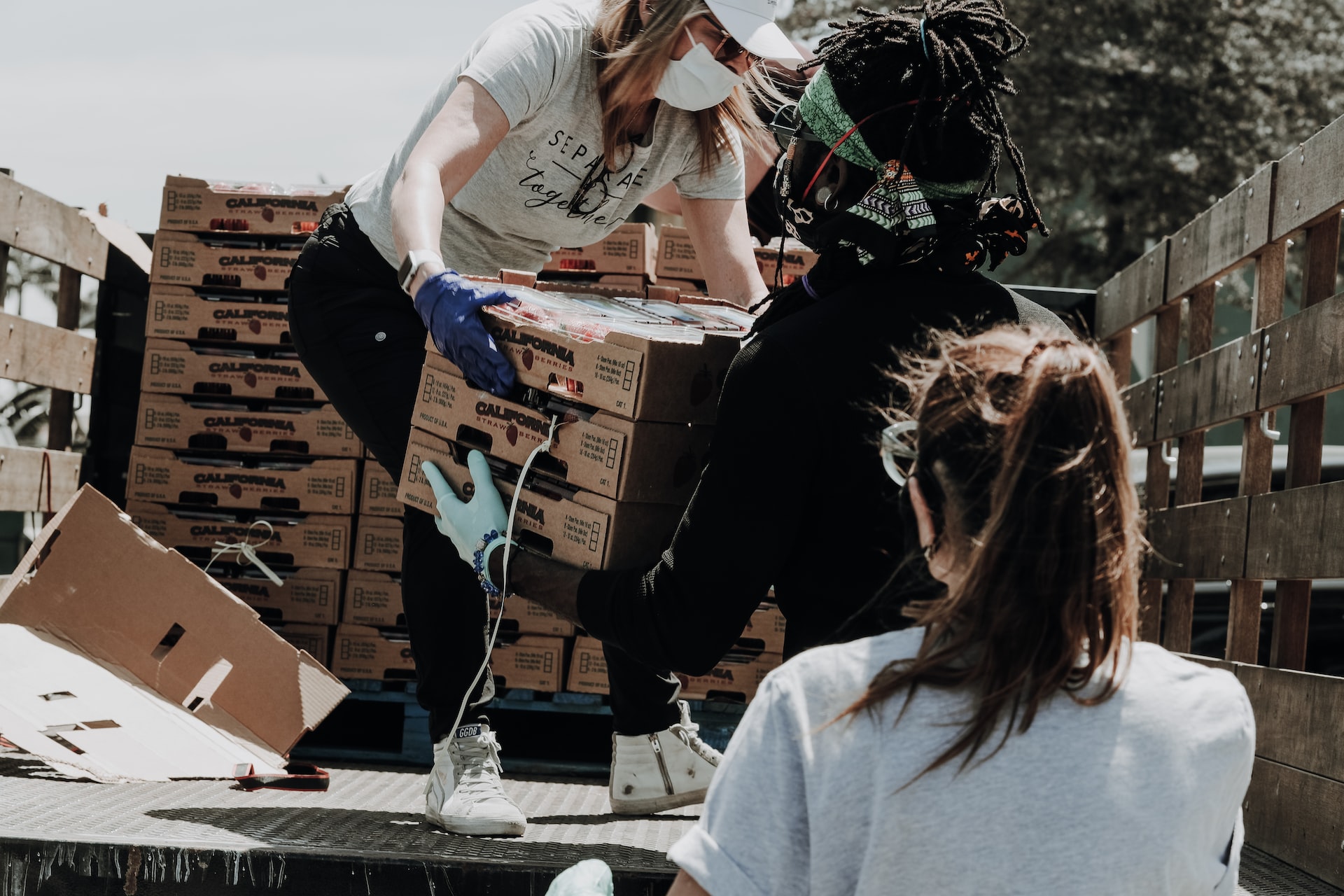 Three people unloading a truck of food donations