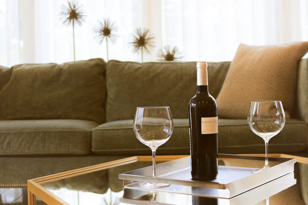 Wine bottle with two glasses on a coffee table. 