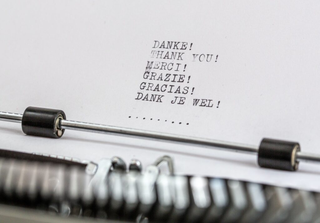 A piece of paper in a typewriter that says "thank you" in many languages