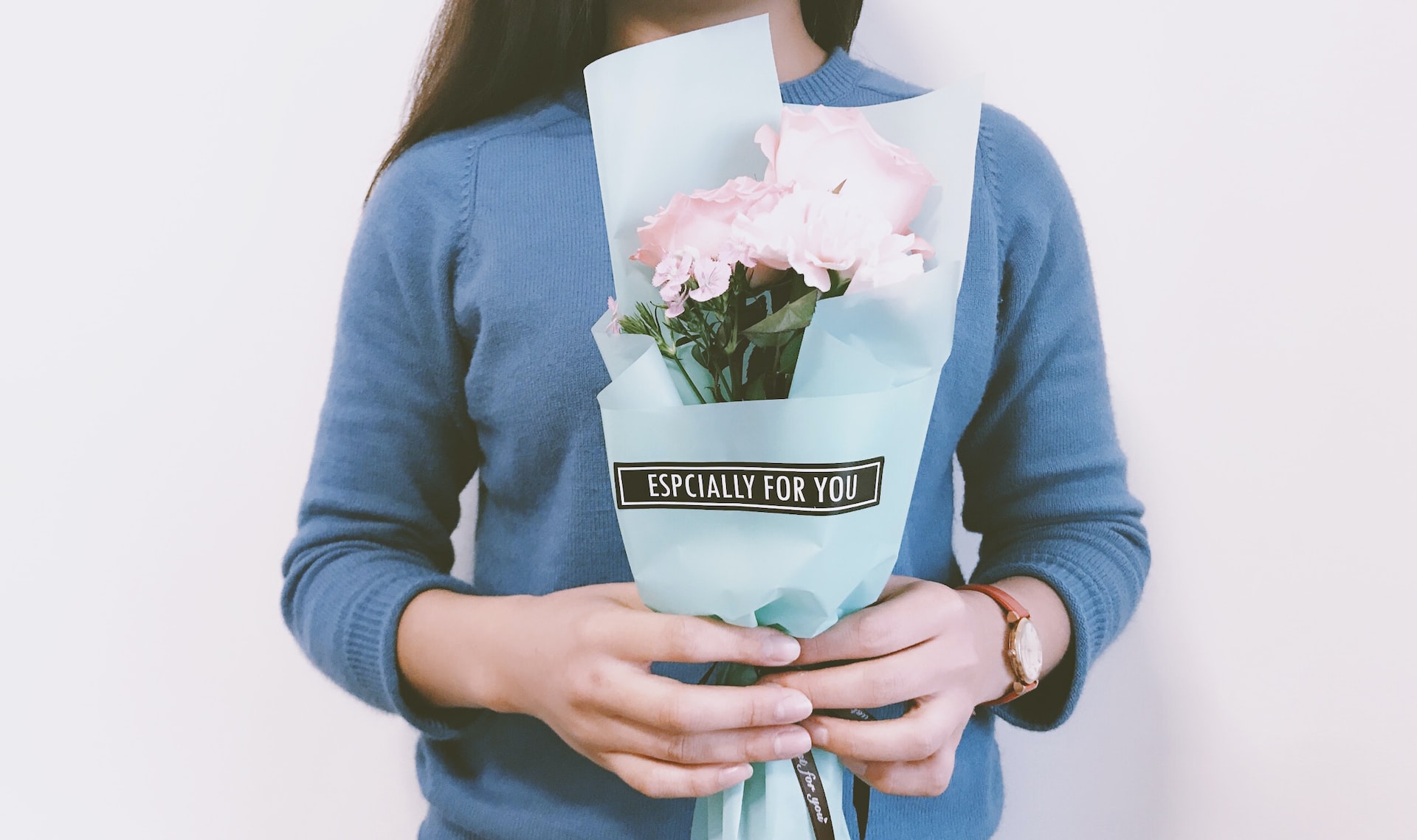 A woman holding a bouquet of flowers that says "especially for you"