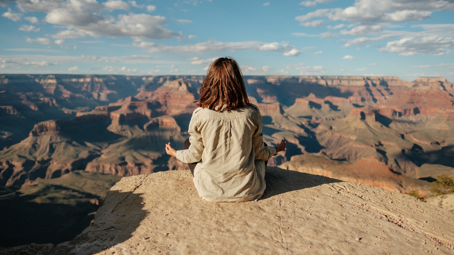 A woman meditating at the edge of the grand canyon.