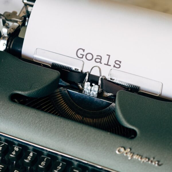 Typewriter with one page of paper that says "goal"