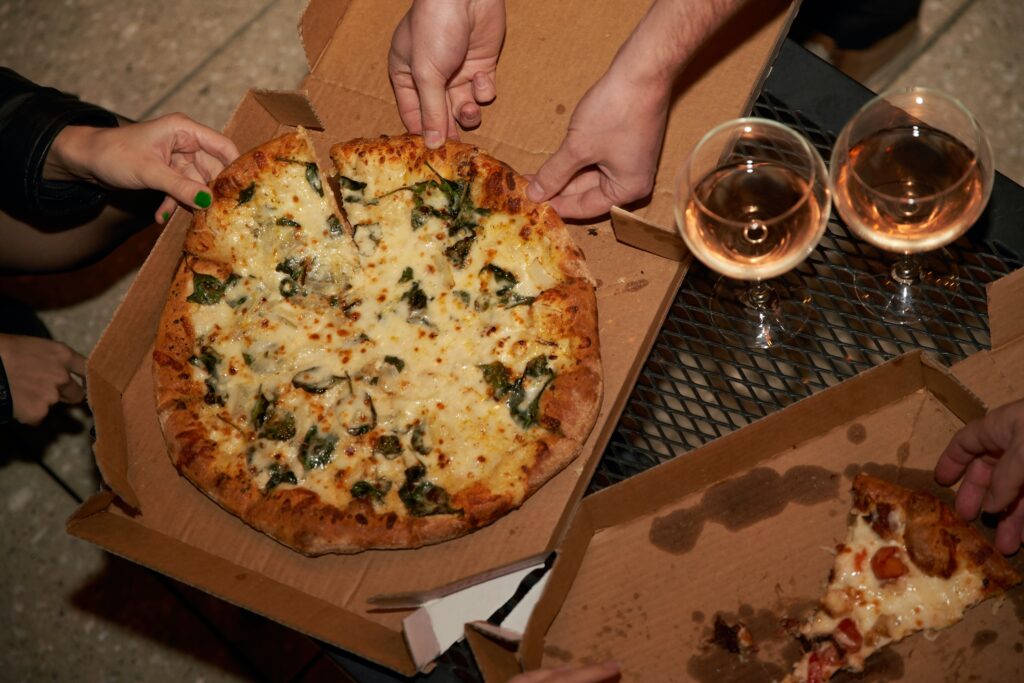 People eating pizza with wine