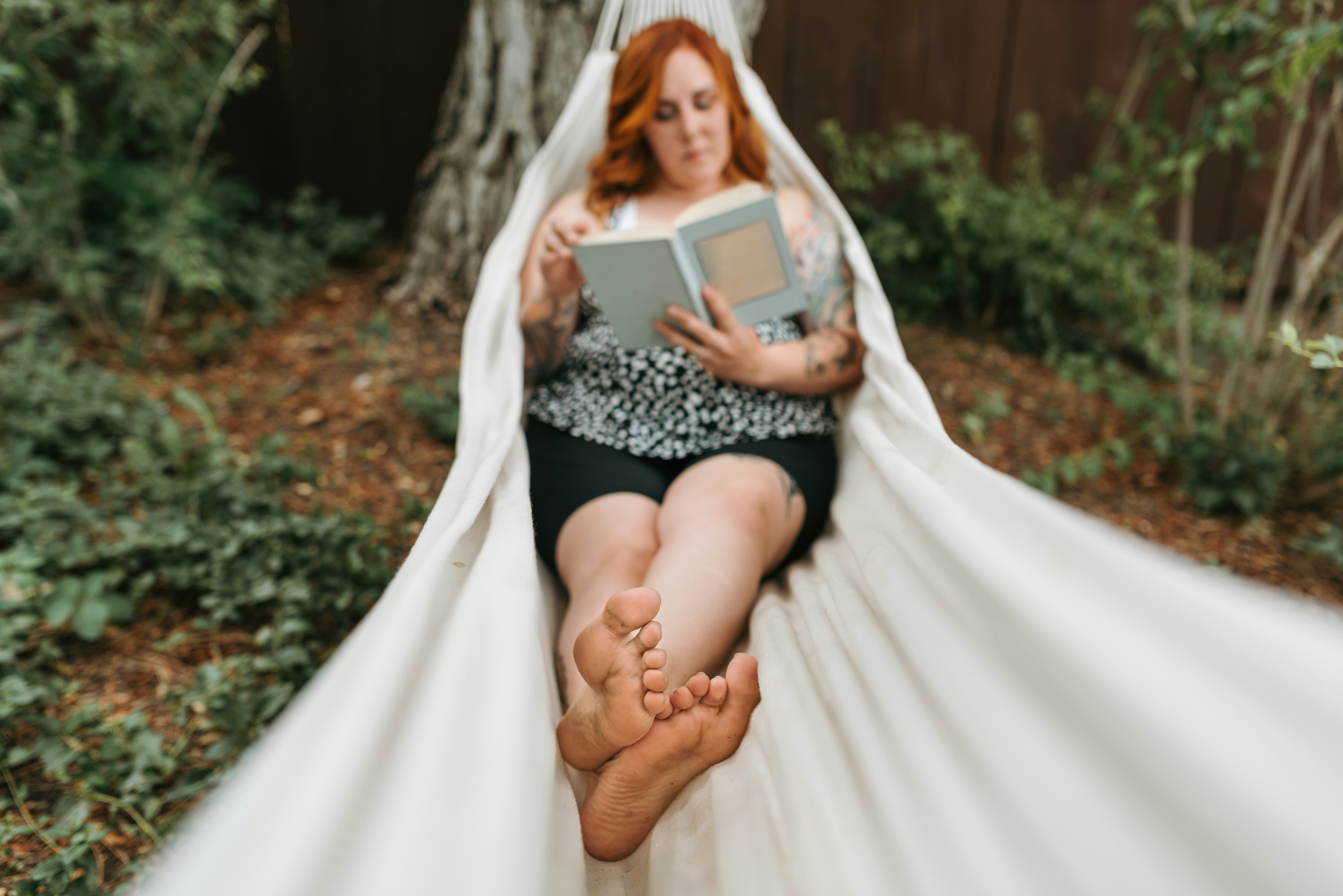 woman relaxing in hammock reading a book