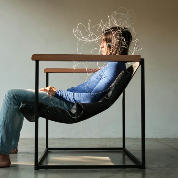 Person sitting on chair with a "cloud" above their head showing stress